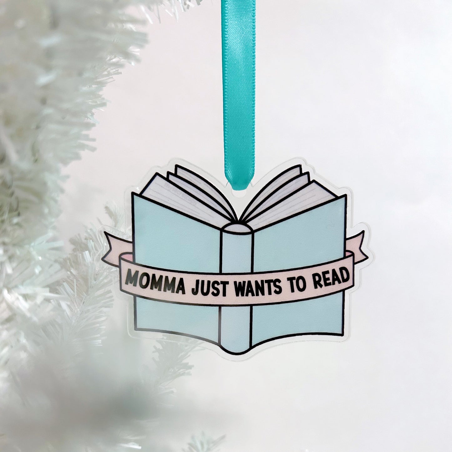 Decorative book ornament with 'Momma just wants to read' text on a white background