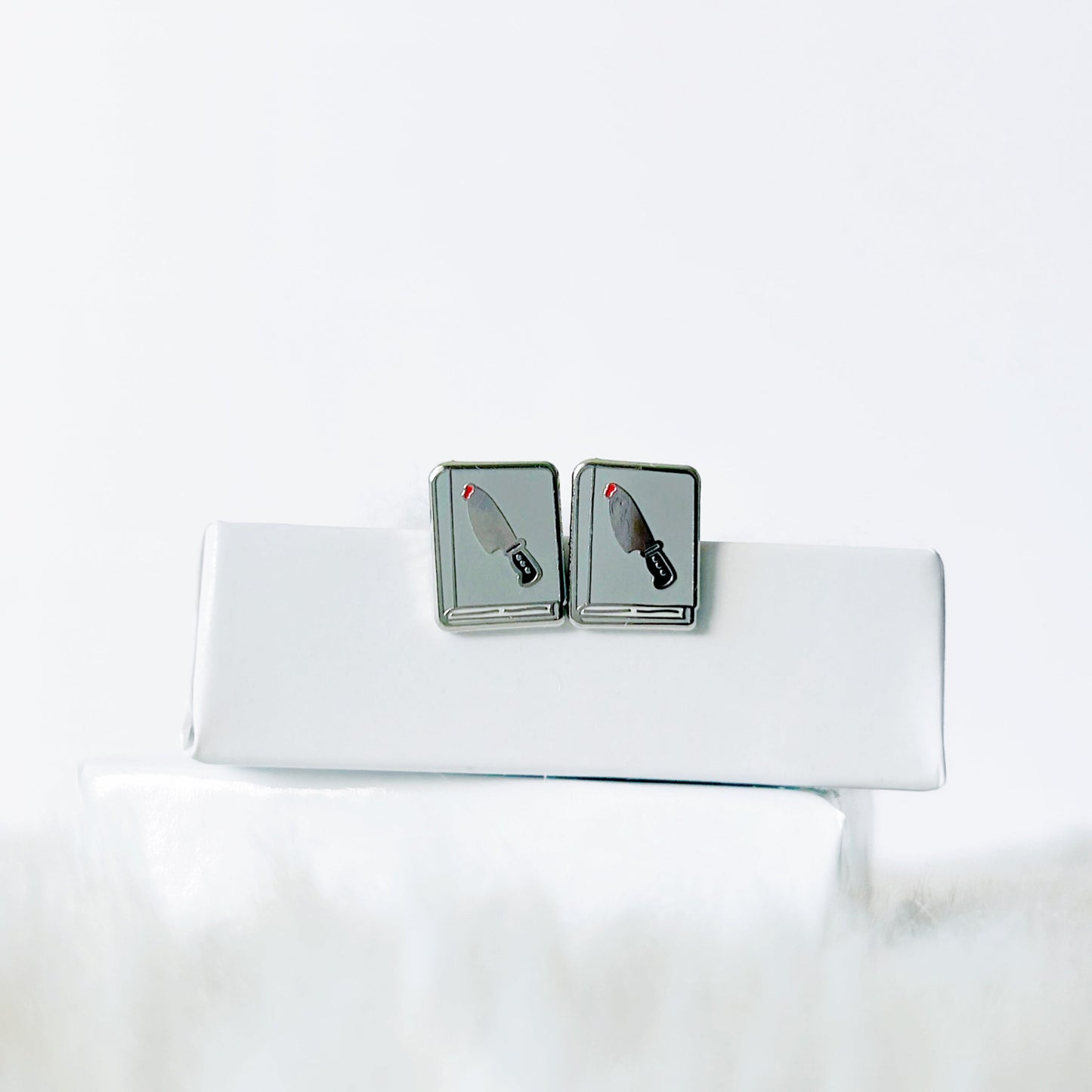 earrings with knife design on a white jewelry box
