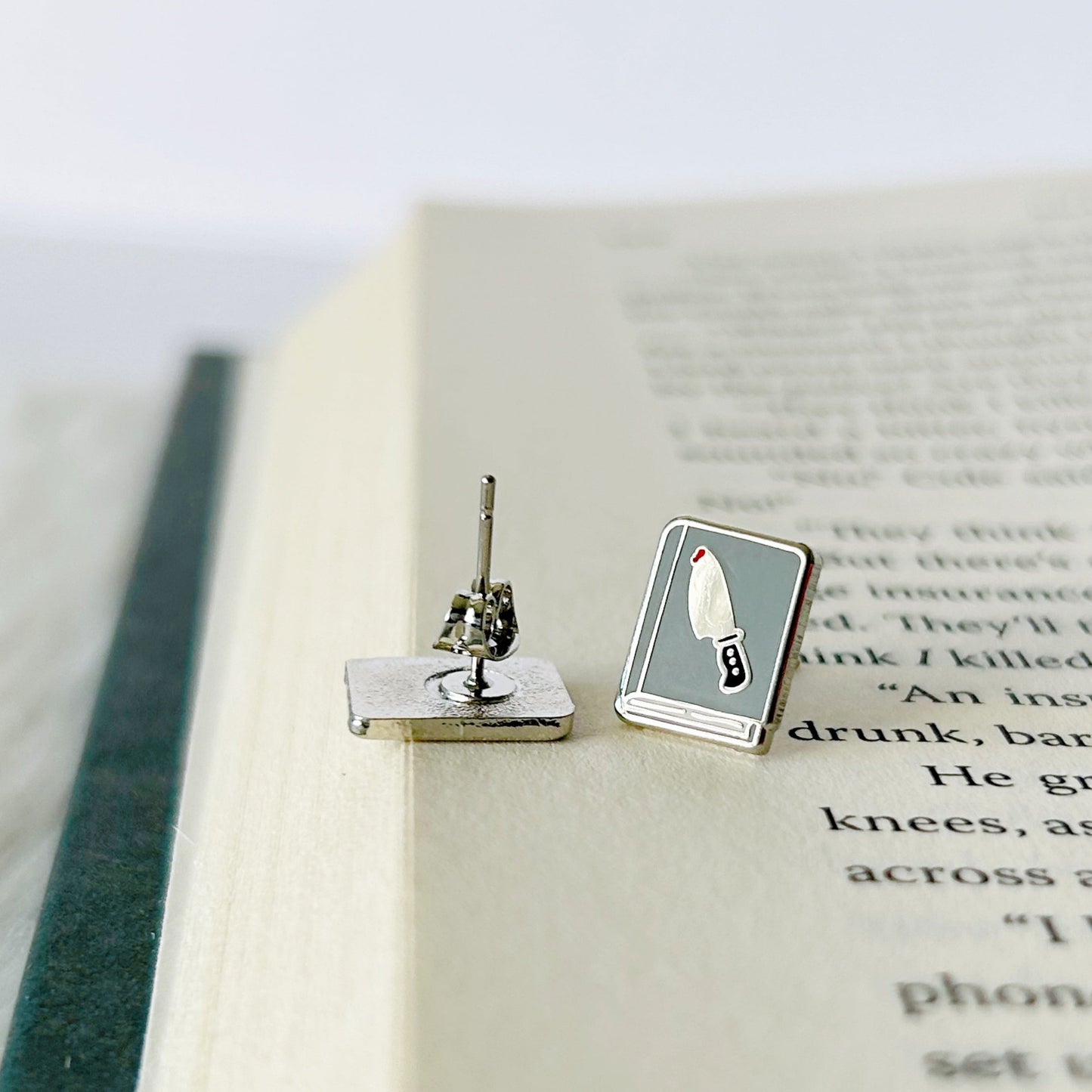 Silver earring with a book design on an open book