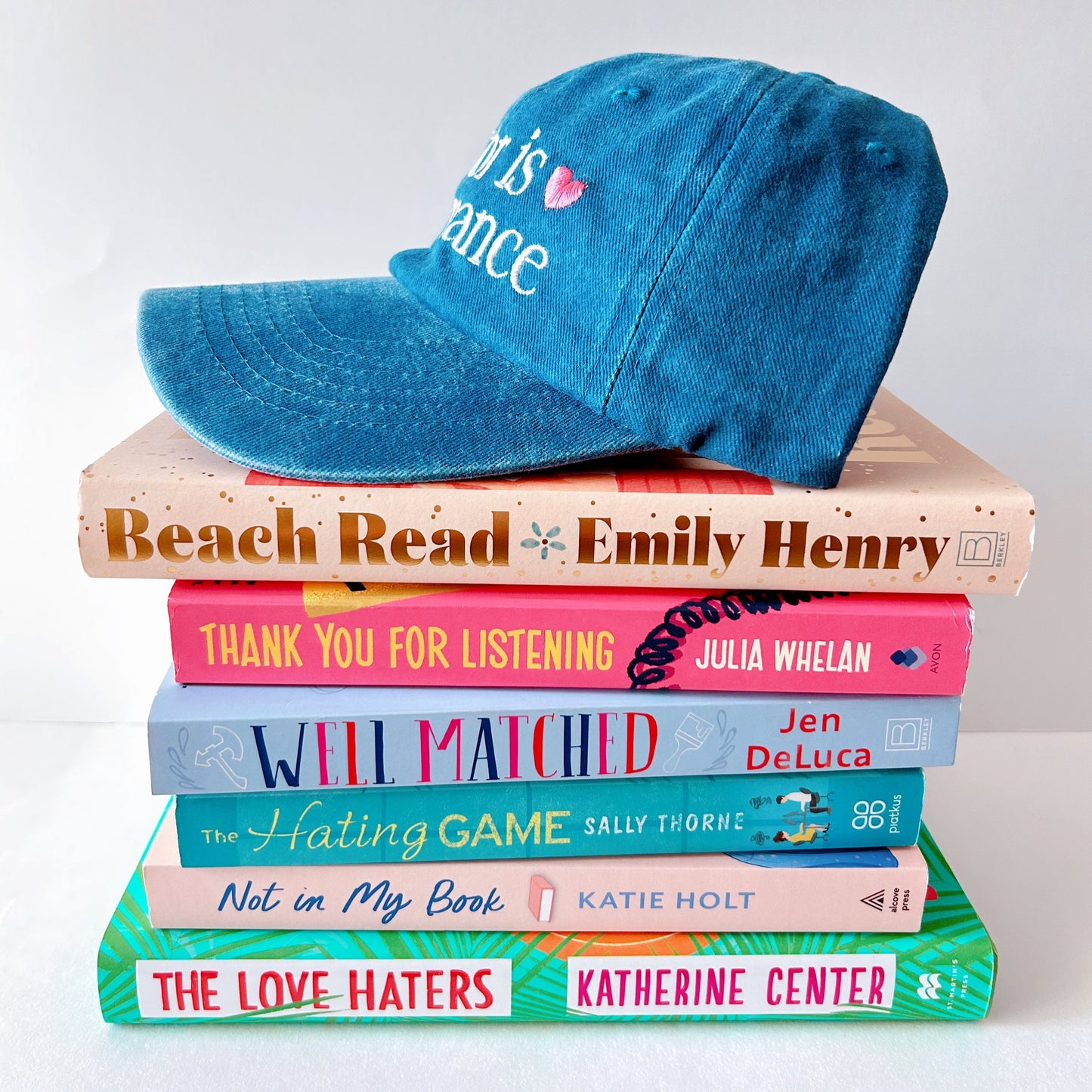 Stack of books with a blue cap on top against a white background