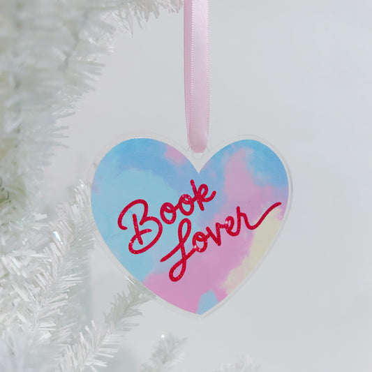 Heart-shaped ornament with 'Book Lover' text on a white Christmas tree.
