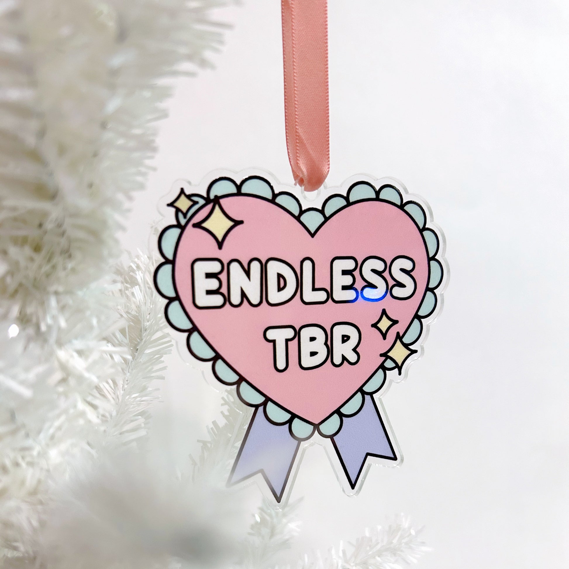 Heart-shaped ornament with 'ENDLESS TBR' text on a white Christmas tree.