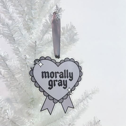 Heart-shaped ornament with 'morally gray' text on a white Christmas tree.