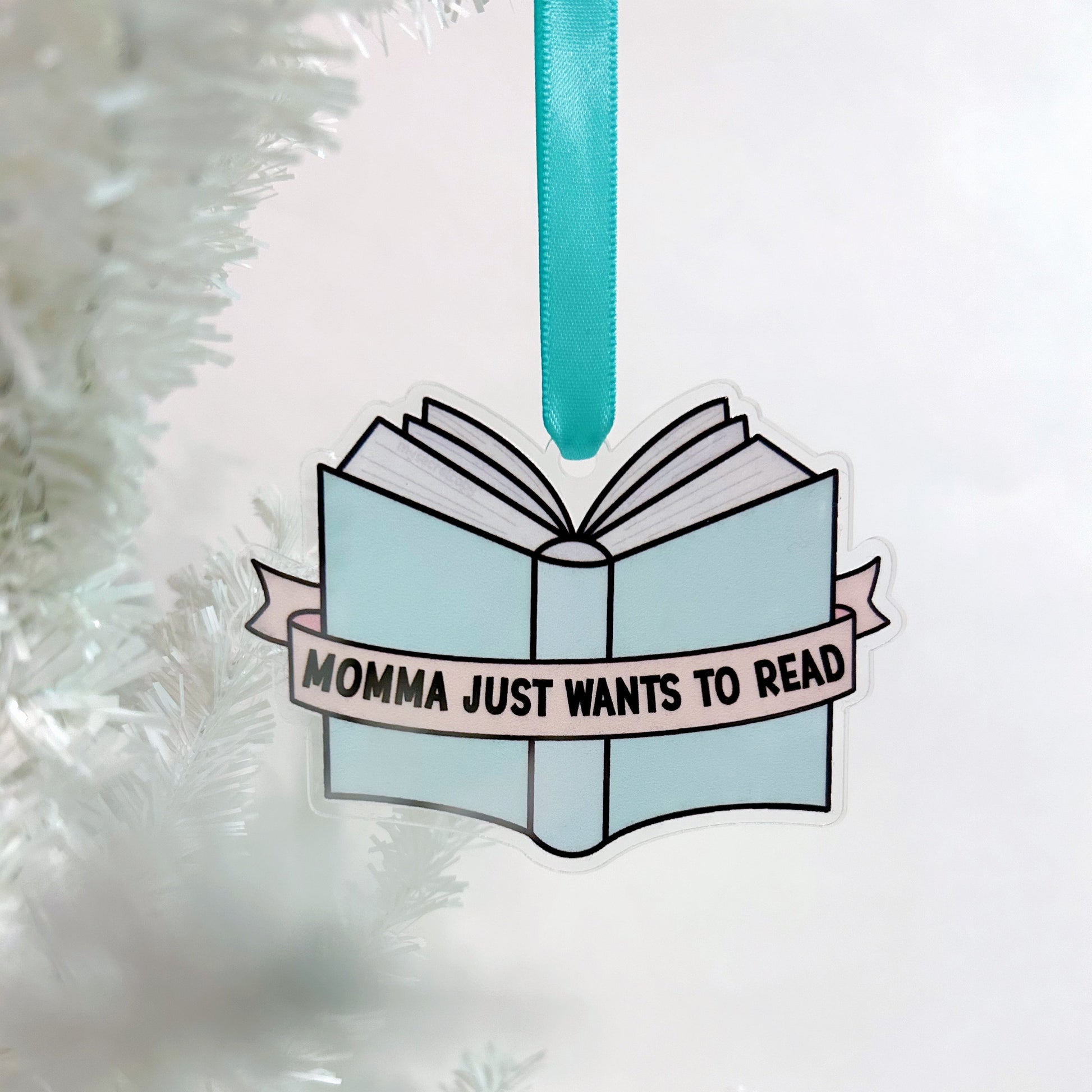 Decorative book ornament with 'Momma just wants to read' text on a white background
