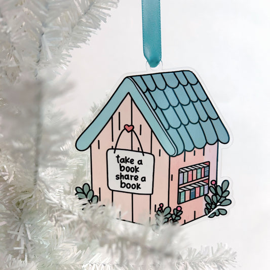 little library ornament with 'take a book, share a book' message hanging on a white tree.