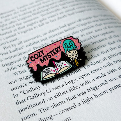 Pin with cozy mystery book club design on an open book