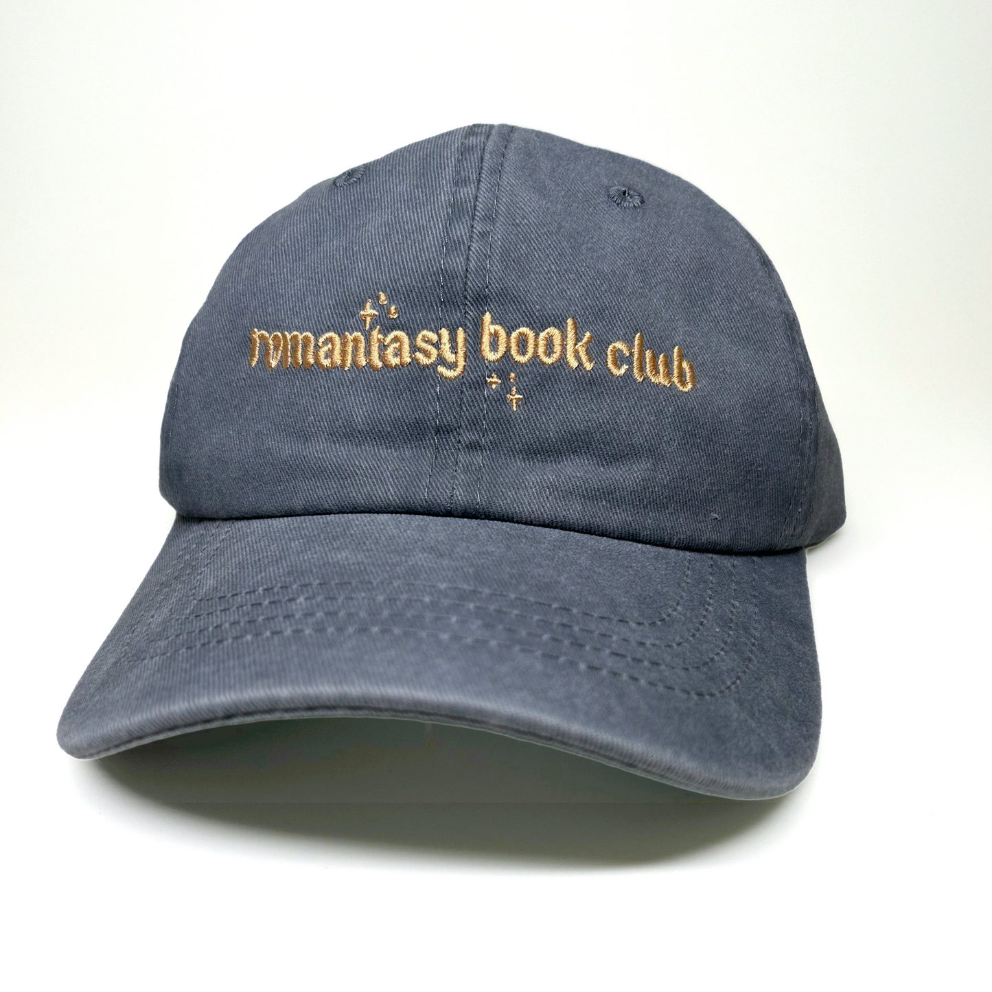 A dark gray cotton baseball cap with 'romantasy book club' embroidered in gold thread on the front, set against a plain white background.