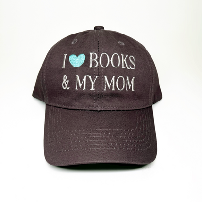 A baseball cap with embroidered text reading 'I [light blue heart] BOOKS & MY MOM' on the front, shown against a plain white background.