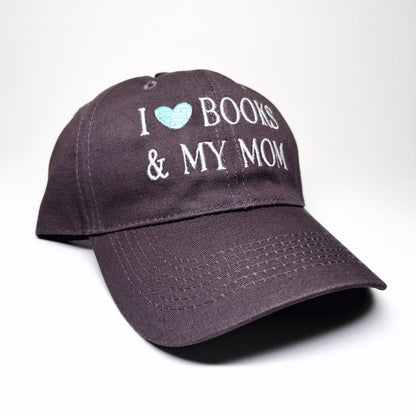 A dark gray baseball cap with embroidered text reading 'I [light blue heart] BOOKS & MY MOM' on the front, shown on a clean white background.