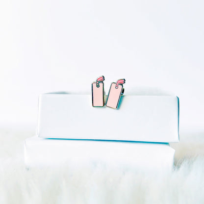 Pink earrings on a white surface with a blurred background