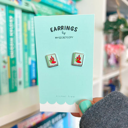 Earring card with earrings on a blurred bookshelf background