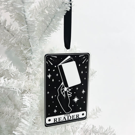 Decorative ornament with 'The Reader' design on a white Christmas tree.